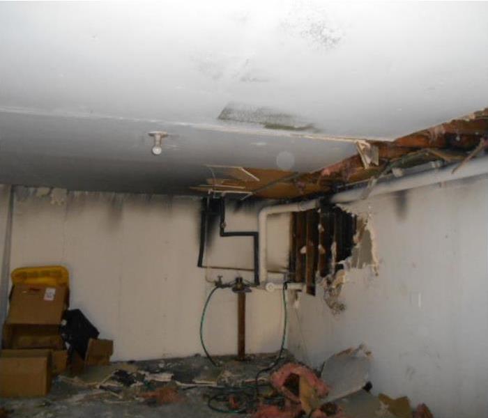 Fire damaged room with soot damage and a collapsed ceiling
