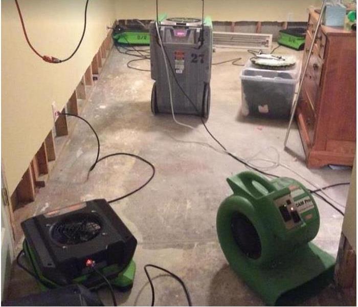 SERVPRO restoration equipment in water damaged room; flood cuts along wall