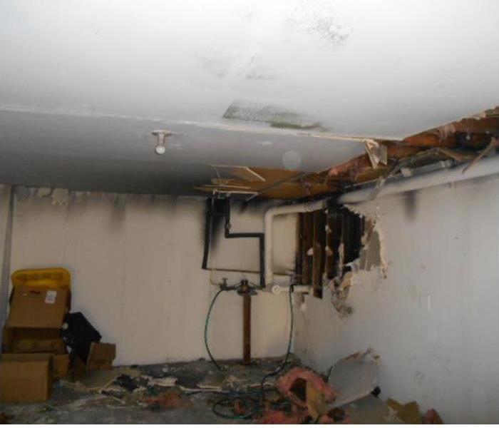 Fire damaged room with soot damage and a collapsed ceiling