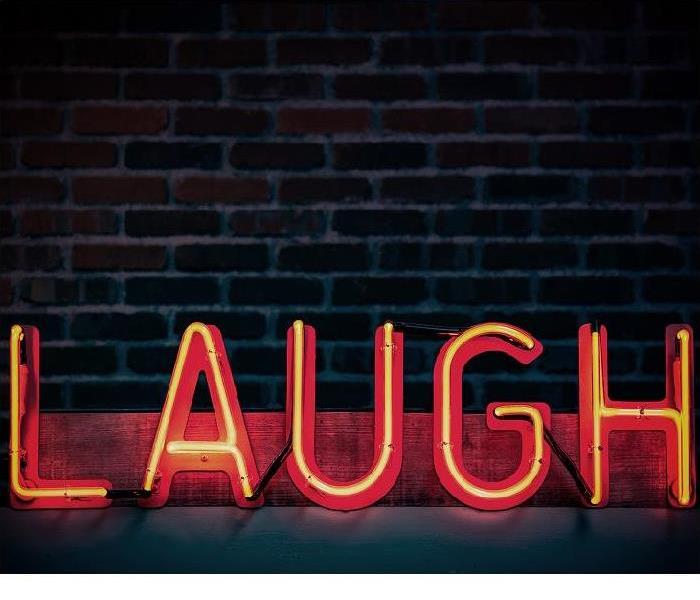 Neon sign that says ‘Laugh’