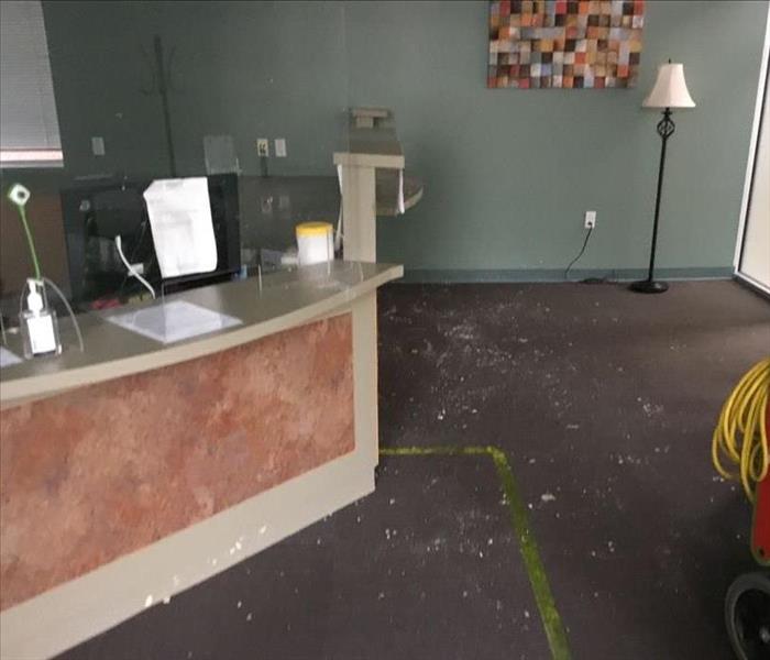 Front desk with debris on carpet and SERVPRO equipment